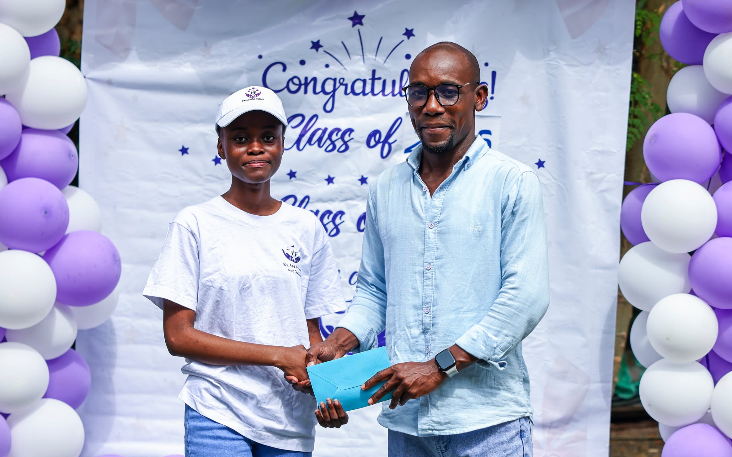 A graduate in Kenya receiving congratulations at a class celebration